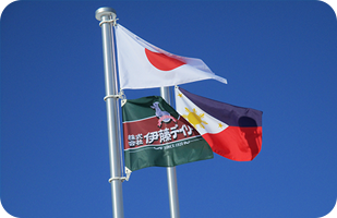 事務所の前庭には牧場の旗とともに、日本と外国人実習生の母国フィリピンの国旗を掲揚している